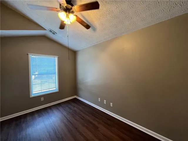 an empty room with a window and wooden floor