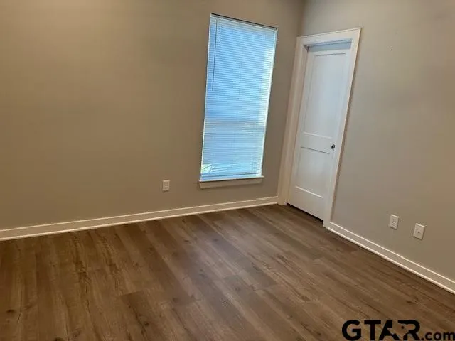 an empty room with wooden floor and closet