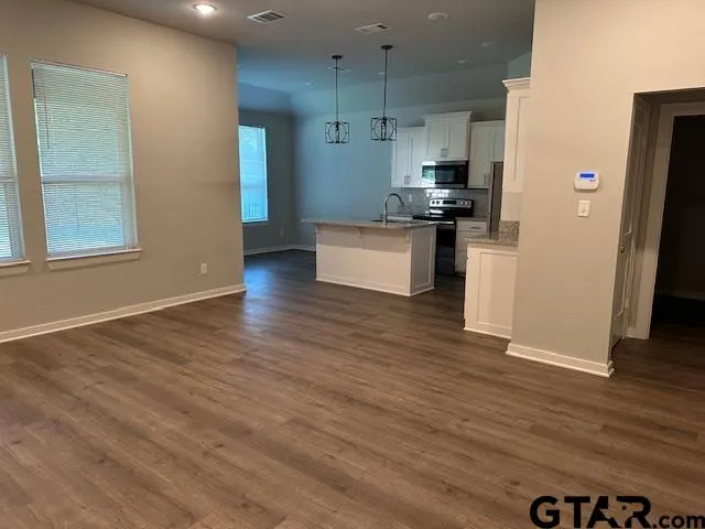 a kitchen with stainless steel appliances granite countertop a refrigerator and a stove top oven