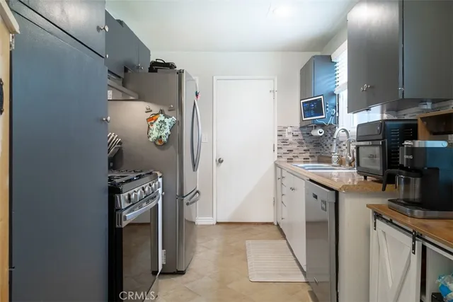a kitchen with stainless steel appliances granite countertop a refrigerator and a stove
