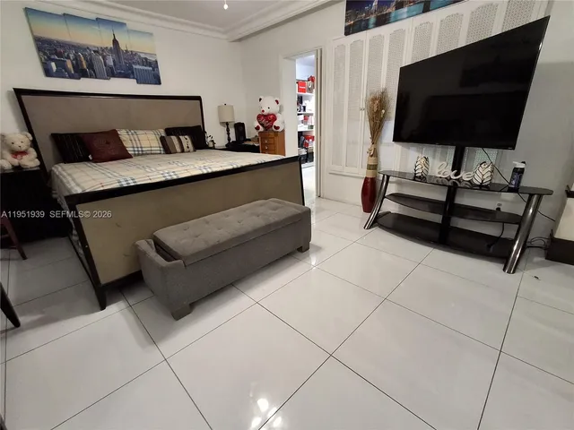 a bedroom with furniture and a flat screen tv