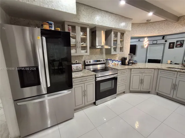 a kitchen with stainless steel appliances granite countertop a refrigerator sink and stove