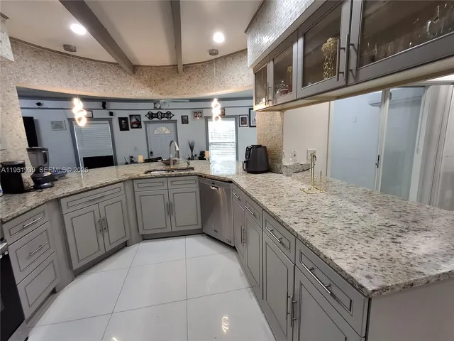 a large kitchen with stainless steel appliances granite countertop a sink and cabinets