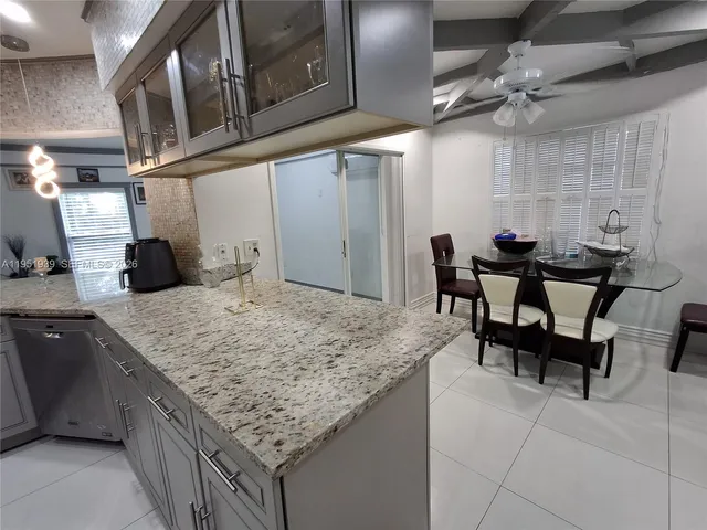 a kitchen with stainless steel appliances granite countertop table chairs and a wooden cabinets