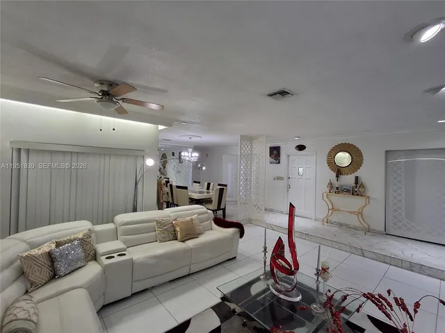 a living room with furniture a rug and gym equipment