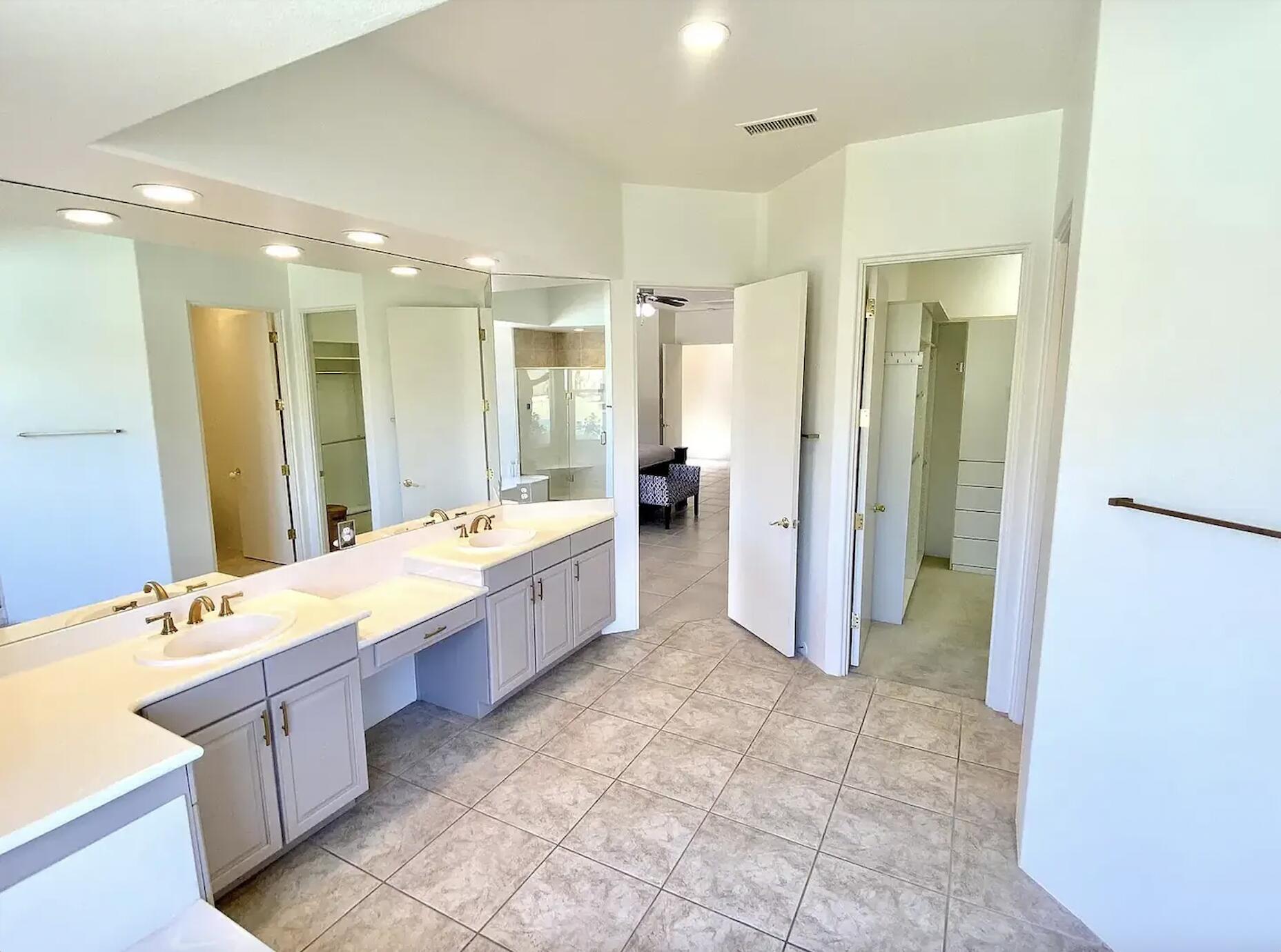 5 Victoria Falls Drive Rancho Mirage, CA 92270 - Photo 22 of 26 a large bathroom with a double vanity sink a large mirror and a shower