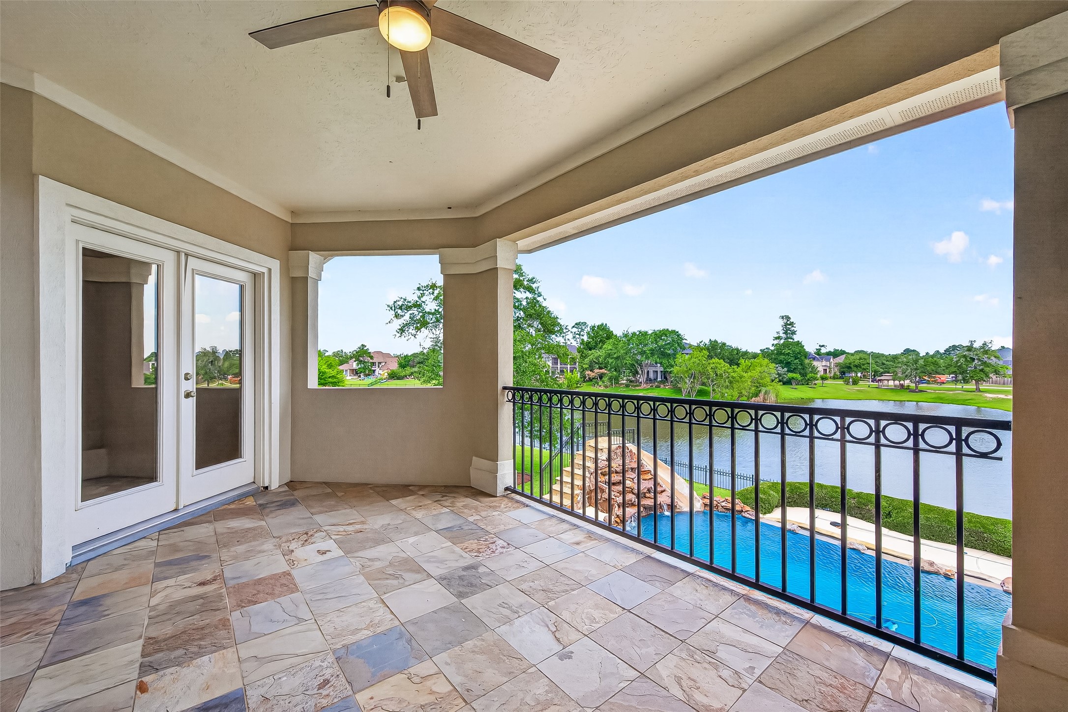 25626 Windy Isle Court Spring, TX 77389 - Photo 32 of 45 A great balcony for relaxation and outdoor enjoyment. Enjoy the stunning view of the pool, lake, lush greenery, and clear blue skies in peace.
