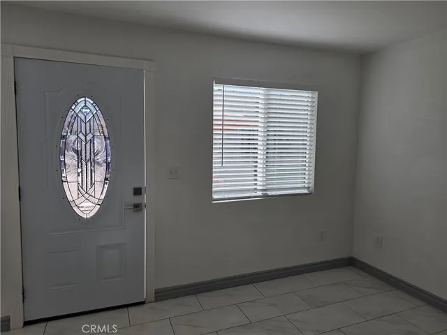 a view of a livingroom with an empty space and a window