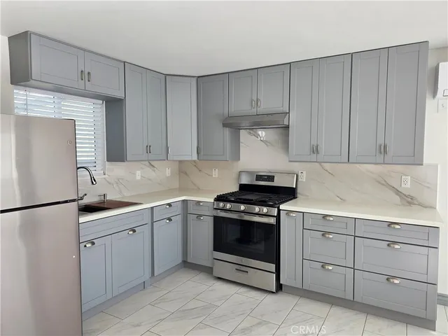 a white refrigerator freezer sitting inside of a kitchen with stainless steel appliances granite countertop cabinets and a stove top oven