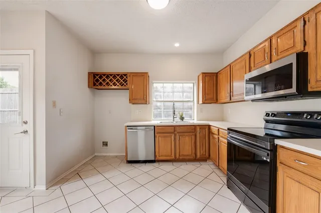 a kitchen with granite countertop cabinets stainless steel appliances and a sink
