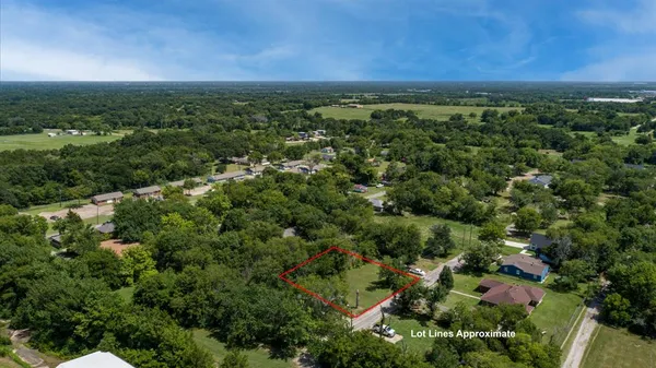 an aerial view of residential houses with outdoor space and trees