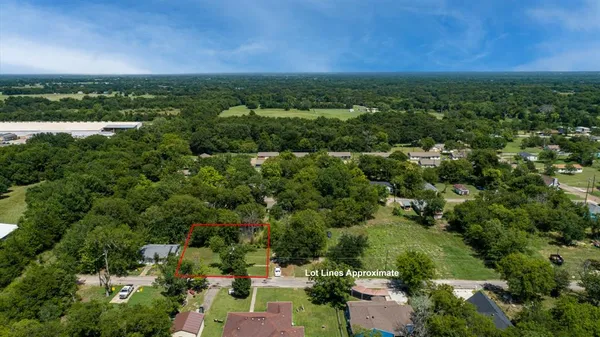 an aerial view of residential houses with outdoor space and trees