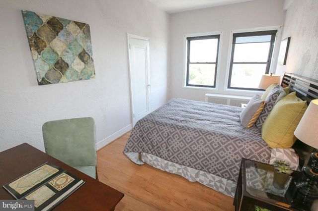 a bedroom with a bed and chair with window