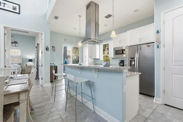 a kitchen with stainless steel appliances granite countertop a stove a sink and a refrigerator