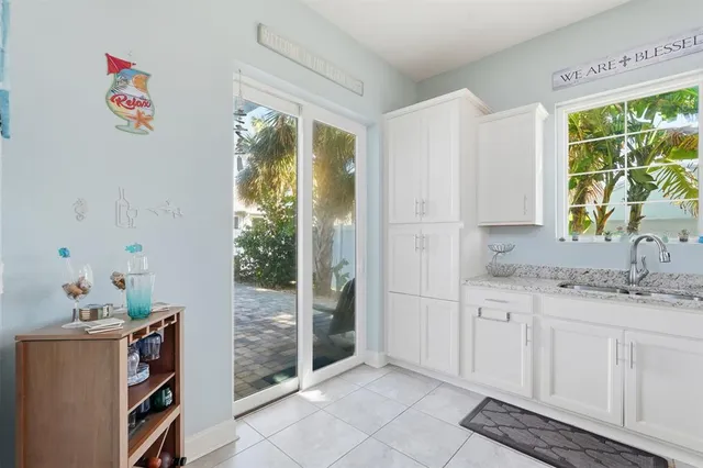 a kitchen with stainless steel appliances kitchen island granite countertop a table chairs sink and cabinets