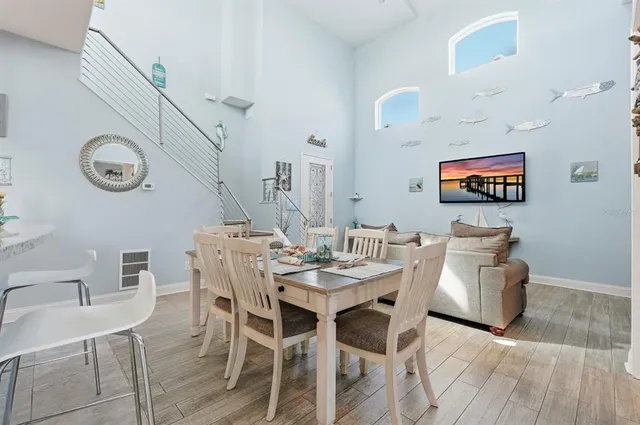 a view of a dining room and livingroom with furniture wooden floor a chandelier