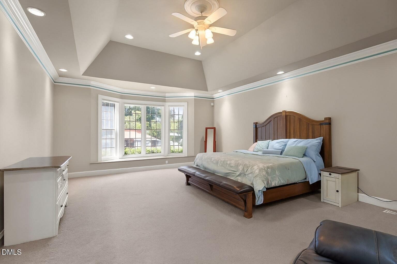5870 Hoyt Road Middlesex, NC 27557 - Photo 5 of 33 a spacious bedroom with a bed and a chandelier