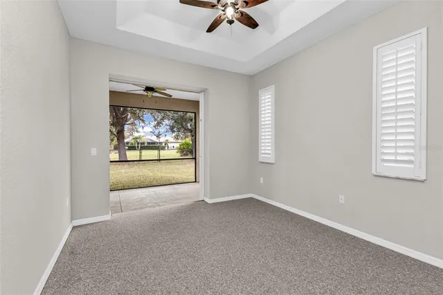 an empty room with a window and a ceiling fan
