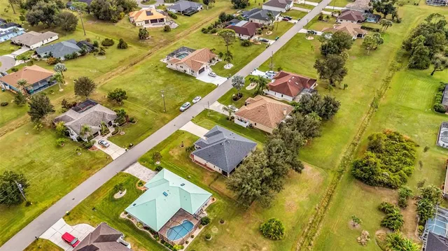 a aerial view of a house with swimming pool and large trees
