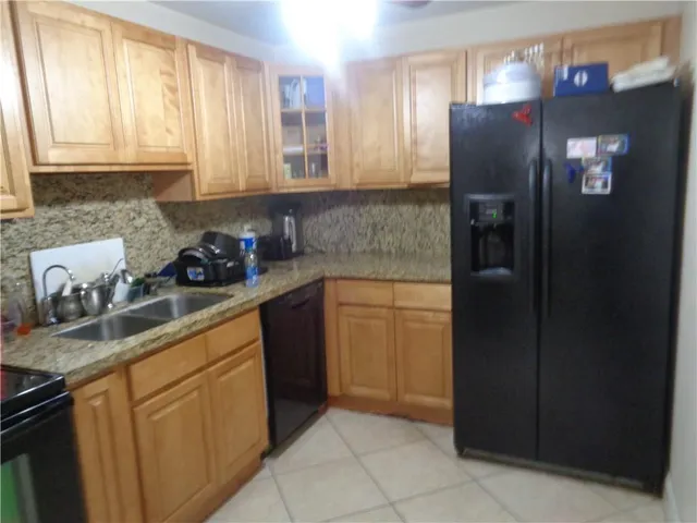 a kitchen with stainless steel appliances granite countertop a refrigerator and a sink