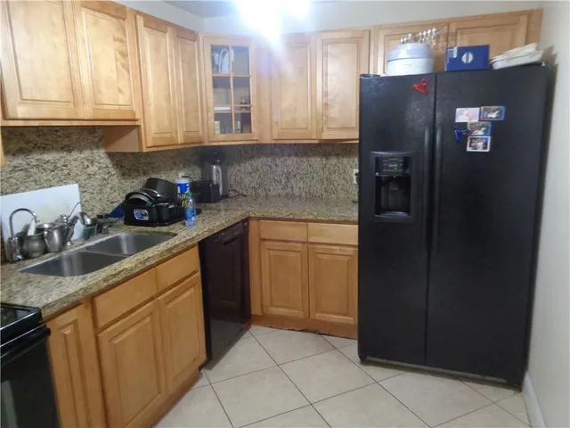 a kitchen with stainless steel appliances granite countertop a refrigerator and a sink