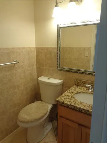 a bathroom with a granite countertop toilet sink and mirror