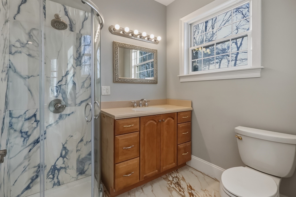 1327 Liberty Street, Unit 2 Braintree, MA 02184 - Photo 13 of 20 a bathroom with a granite countertop toilet sink and mirror