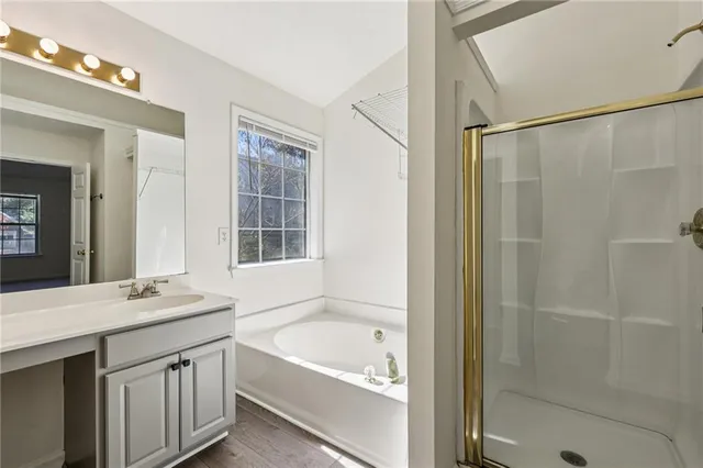 a bathroom with a tub a sink and a large mirror