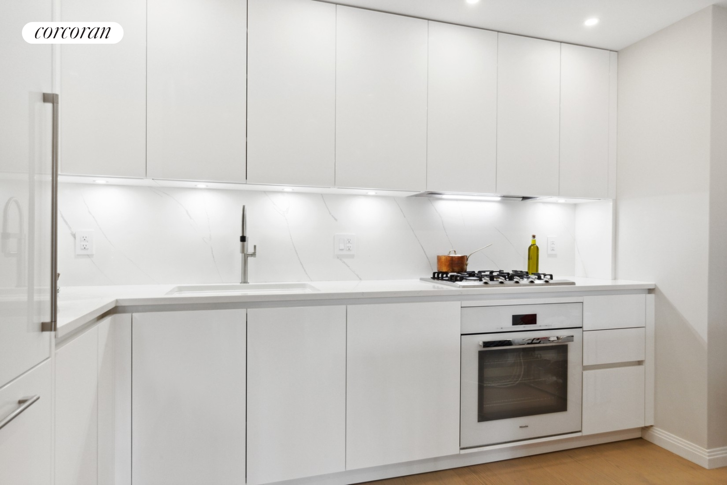 333 Rector Place, Unit 510 Manhattan, NY 10280 - Photo 4 of 10 a kitchen with granite countertop white cabinets and white appliances