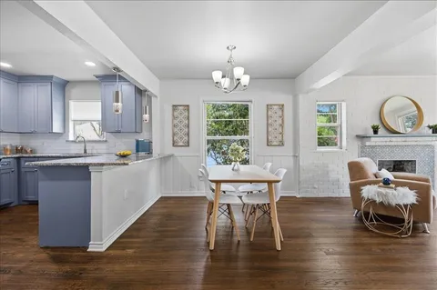 a kitchen with a dining table chairs and microwave