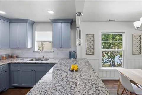 a kitchen with a stove a sink a refrigerator and a view of living room