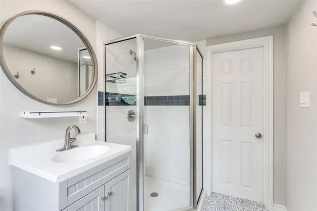 a bathroom with a sink a mirror a vanity and shower
