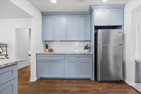 a kitchen with a refrigerator sink and cabinets
