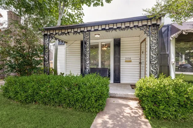 a view of a house with brick walls and flower plants