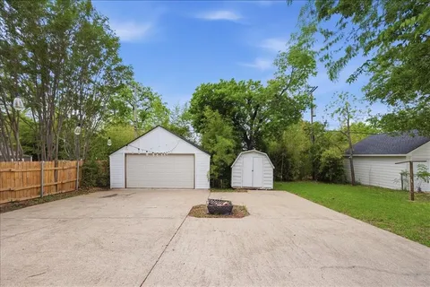 a view of a house with backyard and bushes