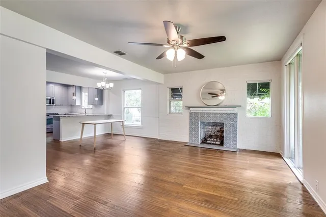 a view of an empty room with a window and fireplace