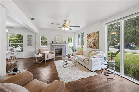 a living room with furniture a fireplace and a large window