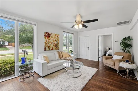 a living room with furniture and wooden floor