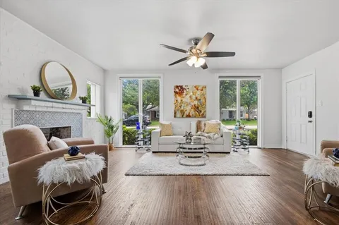 a living room with furniture a fireplace and a floor to ceiling window