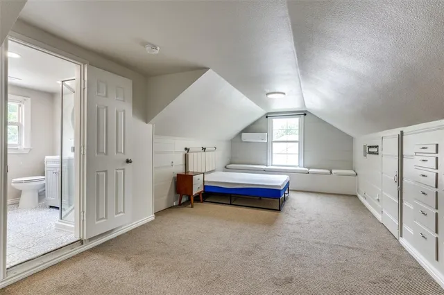 a spacious bedroom with a bed and a window