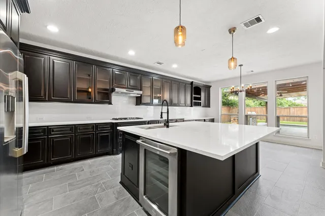 a kitchen with kitchen island granite countertop a sink and a stove