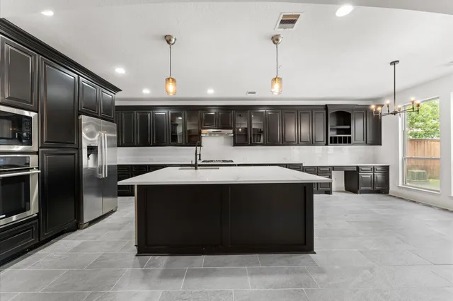 a kitchen with a sink refrigerator and microwave