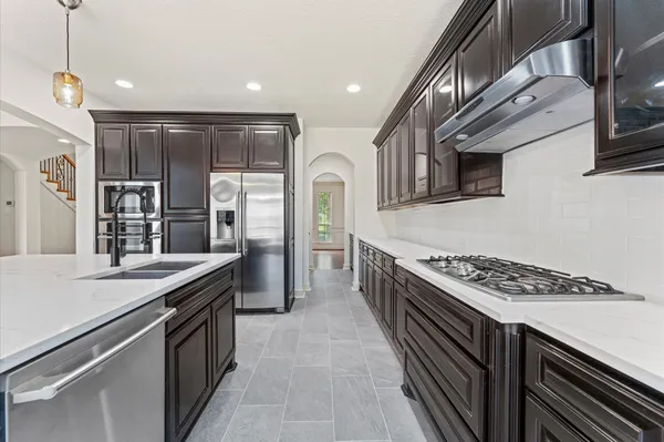 a kitchen with stainless steel appliances granite countertop a stove a sink and a refrigerator