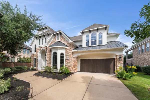 a front view of a house with yard and parking