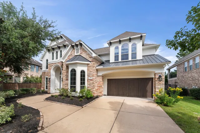 a front view of a house with yard and parking