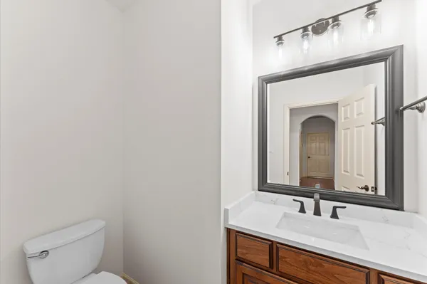 a bathroom with a toilet sink vanity and mirror