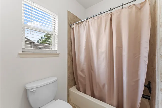 a bathroom with a toilet and a window