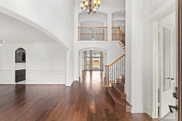 a view of a hallway with wooden floor and staircase