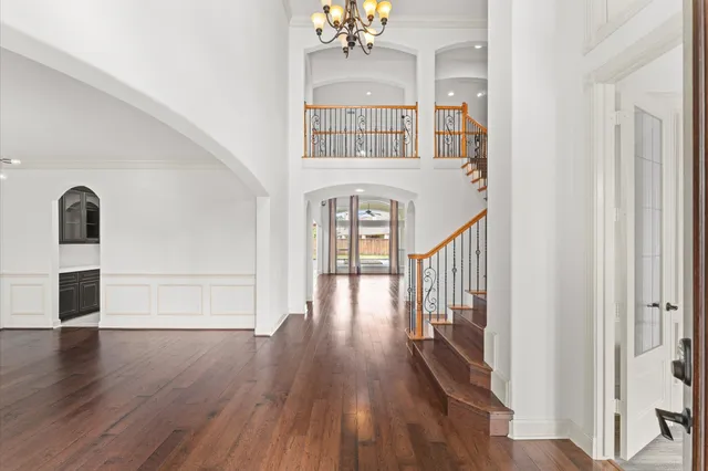 a view of a hallway with wooden floor and staircase