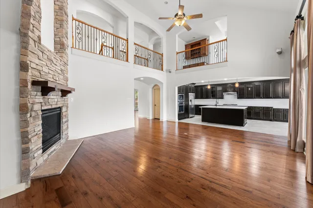a view of a livingroom with furniture wooden floor fireplace and windows